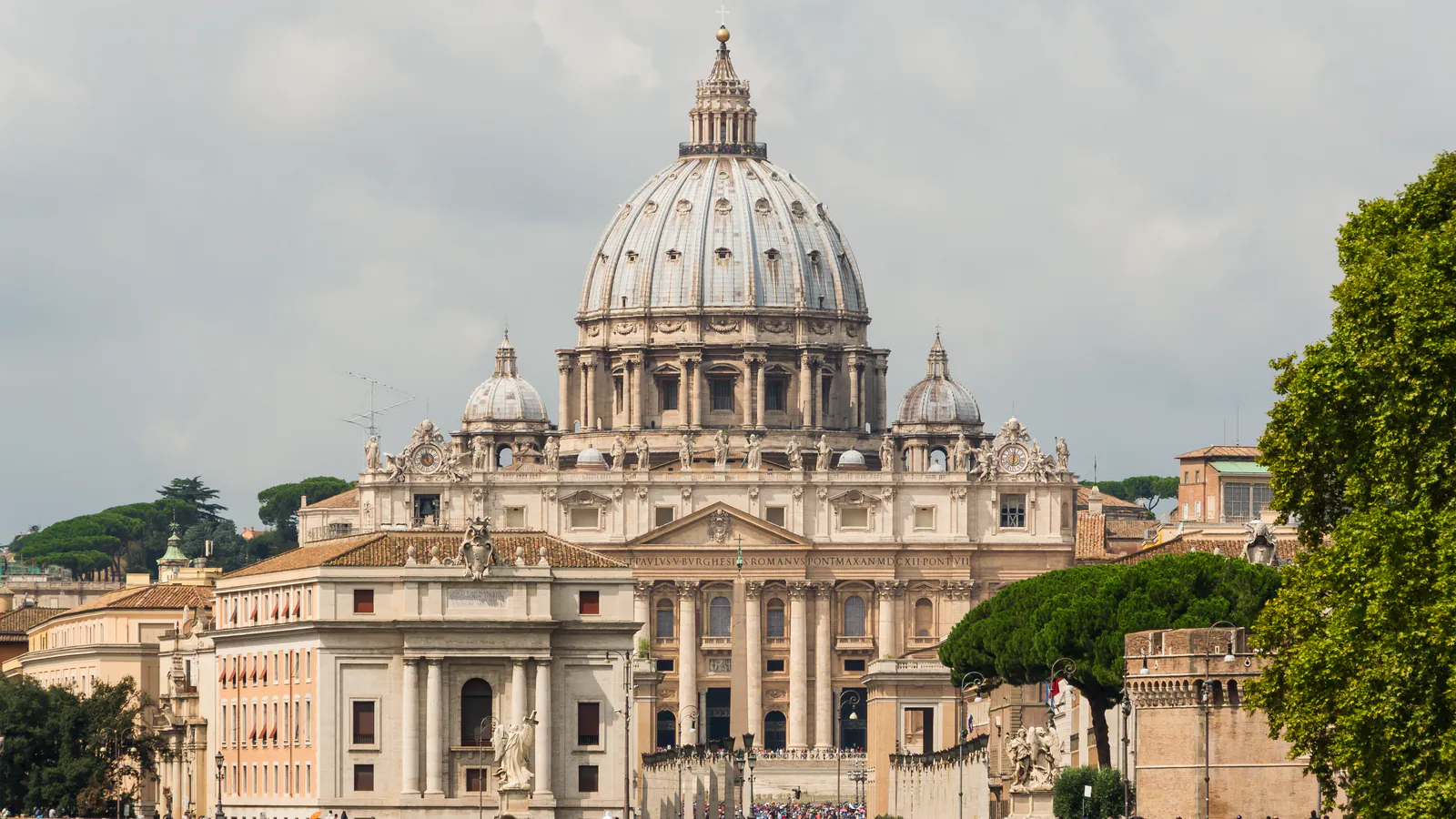 A cúpula e a fachada da Basílica de São Pedro vistas à distância na Cidade do Vaticano